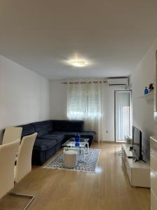 a living room with a couch and a table at Forte Mare Apartment in Podgorica