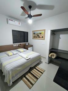 a bedroom with a bed and a ceiling fan at Hotel Graunas in São Carlos
