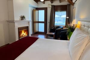 a hotel room with a bed and a fireplace at Hotel Del Lago in Puigcerdà