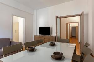 ein Wohnzimmer mit einem weißen Tisch und einem TV in der Unterkunft GuestHost - Ponte Vecchio Charming Apartments in Florenz