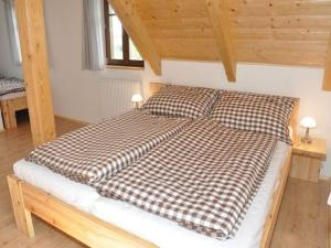 a bed with a checkered comforter in a room at Spacious Group Retreat in Dlouhý