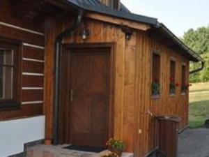 a wooden building with a large door on it at Spacious Group Retreat in Dlouhý
