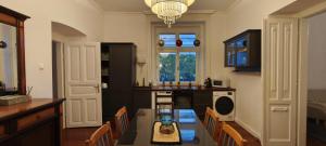 a kitchen with a table with chairs and a dining room at Balatonka Apartman in Alsóörs