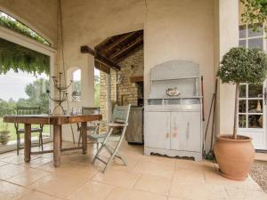 a kitchen with a table and a refrigerator at Villa with Pool in Corrèze in Saint-Bonnet-la-Rivière