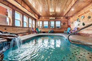 a swimming pool with a waterfall in a house at Smoky Mountain Splash in Sevierville