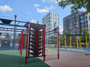 a playground in a city with yellow and red equipment at Nyvky Like Home - Файна Таун із сезонним басейном - Кв 58 in Kyiv