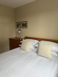 a bedroom with a white bed with two pillows at Spelga View in Newry