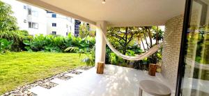 a porch with a hammock and a green yard at Macondo House Private Heated Pool in Medellín