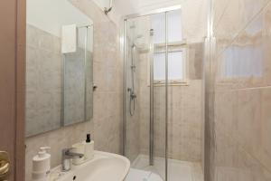 ein Badezimmer mit Glasdusche und Waschbecken in der Unterkunft GuestHost - Ponte Vecchio Charming Apartments in Florenz + 31 Fotos