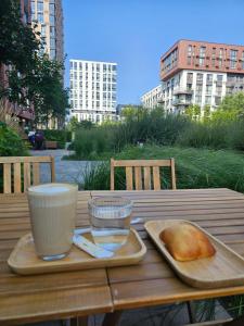 a wooden table with a plate of bread and cups on it at Nyvky Like Home - Файна Таун із сезонним басейном - Кв 58 in Kyiv