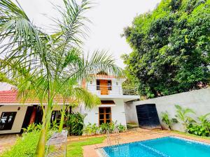 a villa with a swimming pool in front of a house at Courtyard Castle Heritage Resort - Private Villa & Rooms in Pondicherry +62 photos