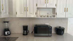 a kitchen with white cabinets and a microwave oven at BLACK&WHITE -Dis Dihai- in Puerto Ayora