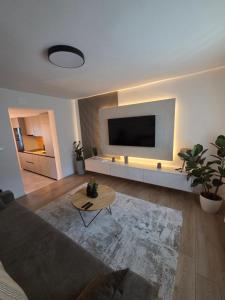 a living room with a couch and a flat screen tv at Apartments Oriens 7 in Zagreb