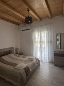 una camera da letto con un letto e una grande finestra di YERODABELO Traditional Family Mansion a Naxos Chora