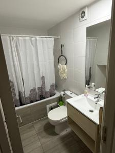 a white bathroom with a toilet and a sink at Departamento centro 2D 2B in Concepción