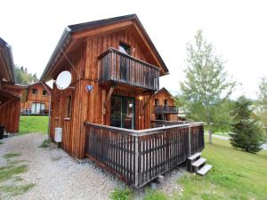 a wooden cabin with a balcony on a field at Chalet in Stadl an der Mur near Ski Slopes in Stadl an der Mur