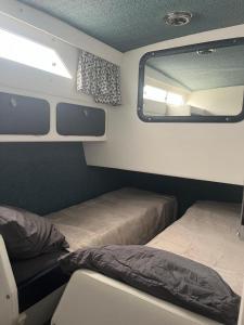a small room with two beds and a mirror at Bateau in Le Barcarès