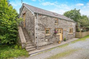 an old stone house with stairs in front of it at The Old Cart House - Crugybar in Rhandirmwyn
