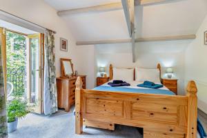 a bedroom with a wooden bed and a window at The Old Cart House - Crugybar in Rhandirmwyn