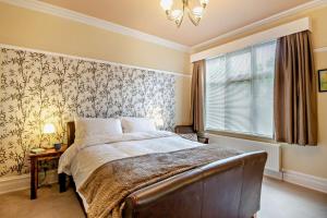a bedroom with a large bed and a window at Redcote in Old Colwyn