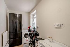 a kitchen with a refrigerator and a washing machine at Avalon in Nottage +30 photos