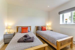 two beds in a small bedroom with two windows at Gwel Y Mynydd in Holyhead