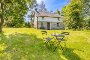 ein Tisch und Stühle vor einem Haus in der Unterkunft Tanybryn Cottage in Llangeitho + 18 Fotos