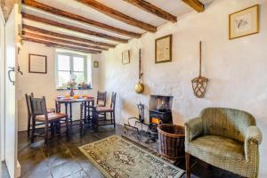 ein Wohnzimmer mit einem Tisch, Stühlen und einem Herd in der Unterkunft Tanybryn Cottage in Llangeitho