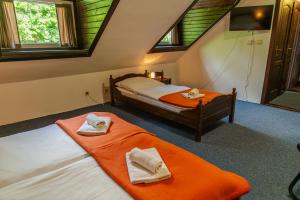 a bedroom with two beds with towels on them at Penzión Kúria in Dolný Kubín