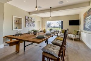 Un comedor con una larga mesa de madera y sillas. en Woodhouse Grange, en Threapwood