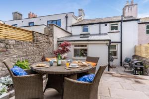 un patio extérieur avec une table et des chaises dans l'établissement Rose Cottage - Crickhowell, à Crickhowell