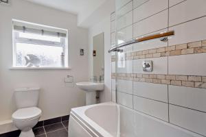 a white bathroom with a toilet and a sink at Nyth yr Wylan in Aberdyfi +16 photos