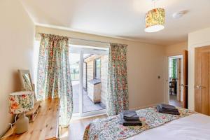 Un dormitorio con una cama y una puerta corrediza de vidrio. en Y Bwthyn Y Berwyn, en Llanarmon Dyffryn-Ceiriog