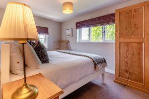 a bedroom with a bed with a lamp and a window at Orlandon Farm Cottage in Saint Brides