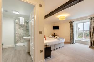 a bedroom with a bed and a sink and a bathroom at 14th Century Retreat in Talsarnau +32 photos