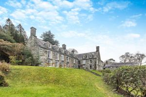 an old stone house on a grassy hill at 14th Century Retreat in Talsarnau