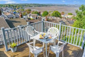 a table with a plate of food on a balcony at Lavender Cottage - Mumbles in The Mumbles