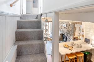 a tiny house with a staircase and a table at Lavender Cottage - Mumbles in The Mumbles +10 photos