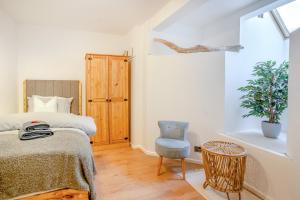 une chambre avec un lit, une chaise et une fenêtre dans l'établissement Riverside Retreat - Cardiff, à Cardiff