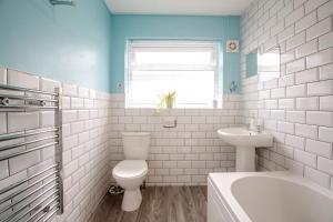 a white bathroom with a toilet and a sink at Cludfan Abersoch in Abersoch +17 photos