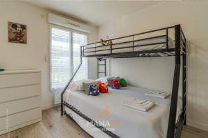 a bedroom with a bunk bed in a room at Le Bora, 6 pers, 10 min Disneyland Paris in Montévrain