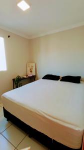 a bedroom with a large white bed in a room at 8º Relax - Cama de Massagem! in Uberlândia