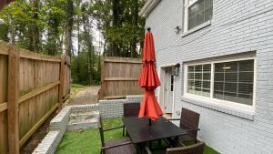 a red umbrella sitting on a table next to a house at Your Private 1-Bedroom Guest House in College Park in College Park