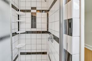 a bathroom with a shower with white tiles at Quaint and Charming Cherry Valley Escape! in Cherry Valley +16 photos