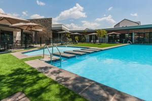 a large swimming pool with blue water in front of a building at AlimamaSpaces Phillys Whisken in Midrand