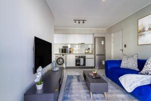 a living room with a blue couch and a table at AlimamaSpaces Phillys Whisken in Midrand