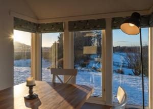 ein Esszimmer mit einem Tisch und einem großen Fenster in der Unterkunft Balass Lodge near The Old Course St Andrews in Fife
