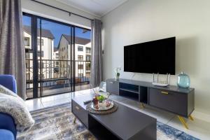 a living room with a tv and a large window at AlimamaSpaces Phillys Whisken in Midrand