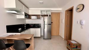 Il comprend une cuisine équipée d'un réfrigérateur et d'une table en bois. dans l'établissement AP822 ar condicionado piscina academia coworking etc, à Juiz de Fora