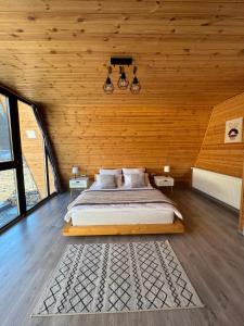 a bedroom with a large bed in a wooden wall at Cabana A Vaideeni in Vaideeni +50 photos